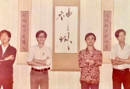1978年指南路二段巷內神州詩社眾人留影，左起廖雁平、周清嘯、溫瑞安及李宗舜。字軸「神州」二字及對聯係作家亮軒（馬國光）手書，影像來源：李宗舜提供。